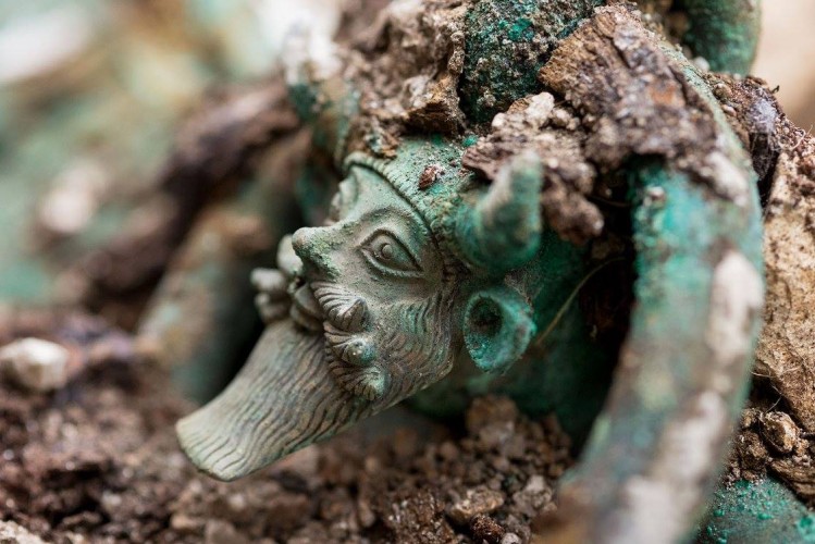 Au fond de la tombe, découverte d'un chaudron en bronze, aux anses décorées du dieu Acheloos. Fouille de Lavau (Aube), 2015. © Denis Gliksman, Inrap