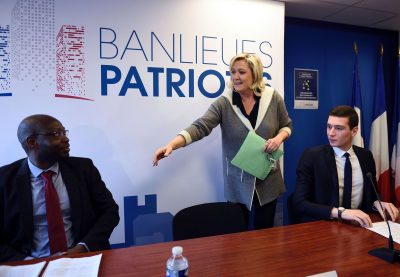 French far-right Front National (FN) party president Marine Le Pen (C) arrives to delivers a press conference with FN members Guy Deballe (L) and Jordan Bardella (R) during the launch of the new FN collective "Banlieues patriotes" (Patriotic Suburbs) at the FN headquarter on January 26, 2015 in Nanterre, west of Paris. Le Pen advocated a global "national policy" rather than a specific "city" policy regarding suburbs during the launch of the Patriotic Suburbs collective on January 26, of which 20-year-old Ile de France regional council member, elected in Seine-Saint-Denis, Jordan Bardella which be the president. / AFP / ERIC FEFERBERG